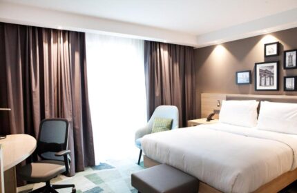Hampton by Hilton Berlin City East Side Gallery guest room. Pet-friendly, gay-friendly hotel bedroom with bed, desk, and chair. Modern decor.