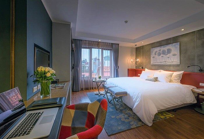 Trendy room at Hanoi La Siesta Hotel. Gay-friendly hotel with desk, laptop, bed, and city view. Ideal for gay men travel in Hanoi.