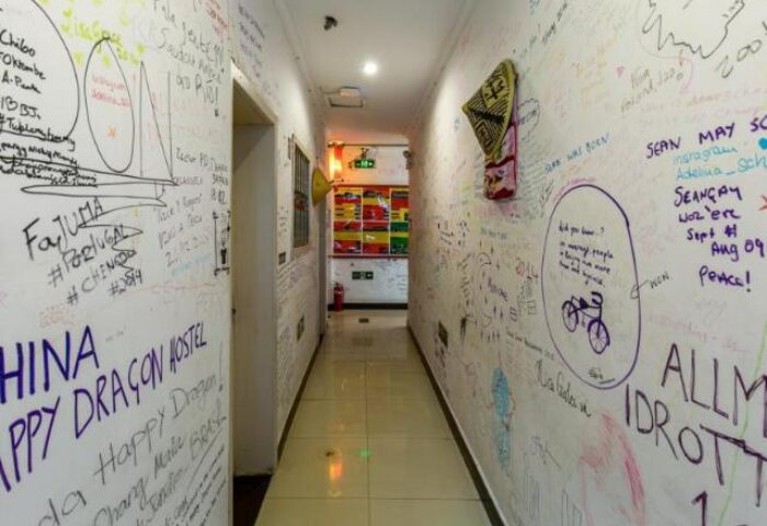Hallway at Happy Dragon Backpackers Hostel, a gay-friendly hotel. Walls are covered in guest signatures and drawings. Great for gay men travelers.