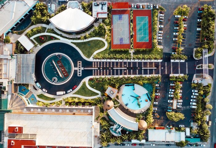 Aerial view of Hard Rock Hotel Cancun All Inclusive, a gay-friendly hotel. Guitar-shaped pool, tennis, & basketball courts. Palm trees & parking.