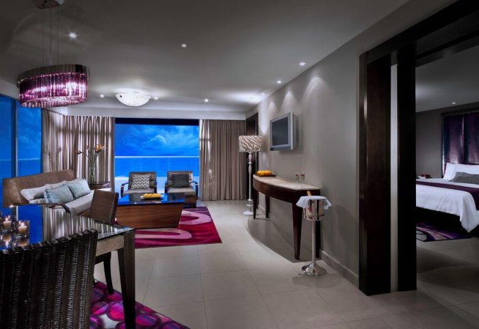 Hard Rock Hotel Cancun All Inclusive gay-friendly suite. Ocean view, living room, dining area, and bedroom. Luxury travel for gay men.
