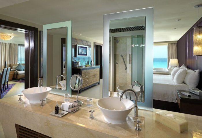 Hard Rock Hotel Cancun All Inclusive bathroom. Upscale gay-friendly hotel with double sinks, mirrors, and views of the bedroom and ocean.