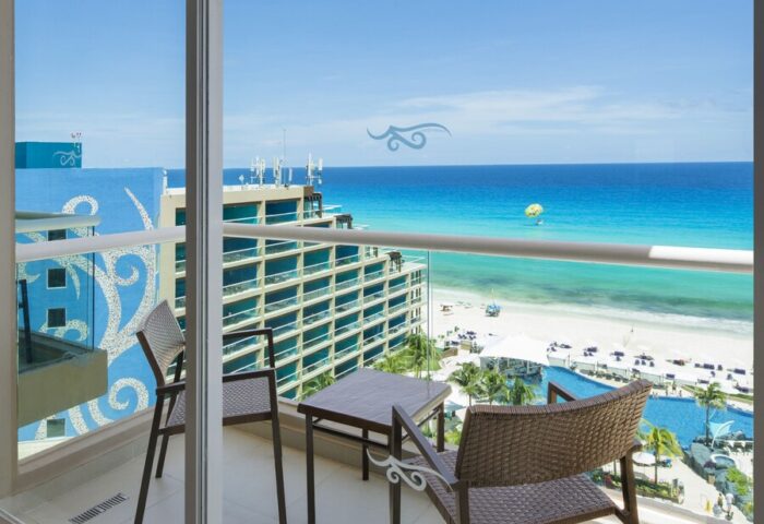 Hard Rock Hotel Cancun all-inclusive balcony view. Gay-friendly hotel room overlooking beach, ocean, and pool. Perfect for gay travel.