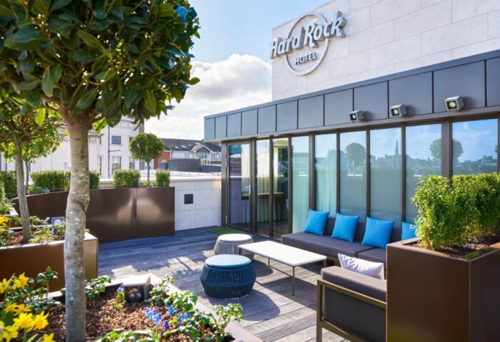Hard Rock Hotel Dublin rooftop lounge. Gay-friendly hotel with outdoor seating, blue pillows, and city views. Dublin travel advice.