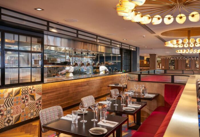 Hard Rock Hotel Dublin's restaurant. Gay-friendly hotel with stylish dining. Tables set, open kitchen view. Dublin travel advice.