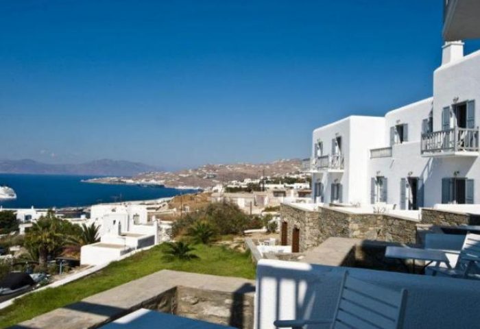 Hermes Mykonos Hotel view. Gay-friendly hotel with whitewashed buildings, balconies, and sea view. A perfect gay travel destination in Mykonos.