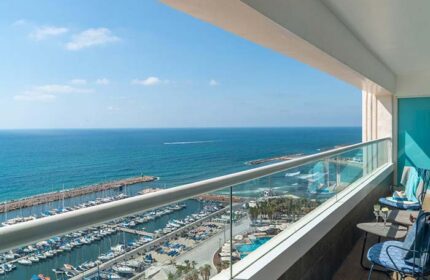 Herods Tel Aviv By The Beach hotel balcony view. Marina, sea, and beach visible. Gay-friendly hotel for gay men's travel in Tel Aviv.