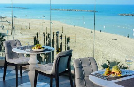 Herods Tel Aviv By the Beach: Dining with a view at this gay-friendly hotel. Tables set for meals overlook the beach and Mediterranean Sea.