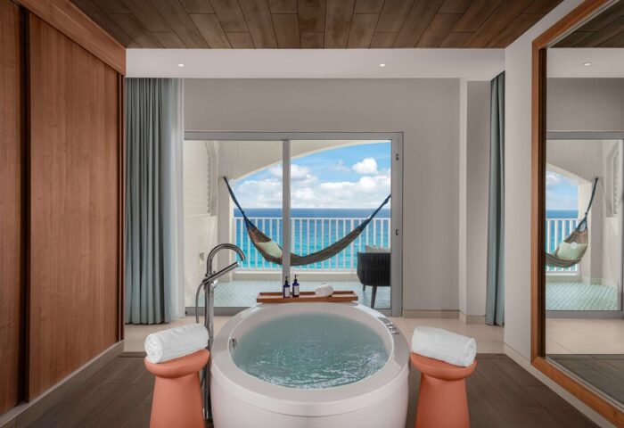 Hilton Cancun Mar Caribe All-Inclusive Resort gay-friendly hotel room. Bathtub, ocean view balcony with hammock. Luxury travel.