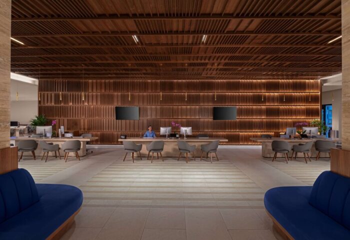 Hilton Cancun Mar Caribe All-Inclusive Resort lobby. Gay-friendly hotel with modern design, wooden accents, and check-in desks.