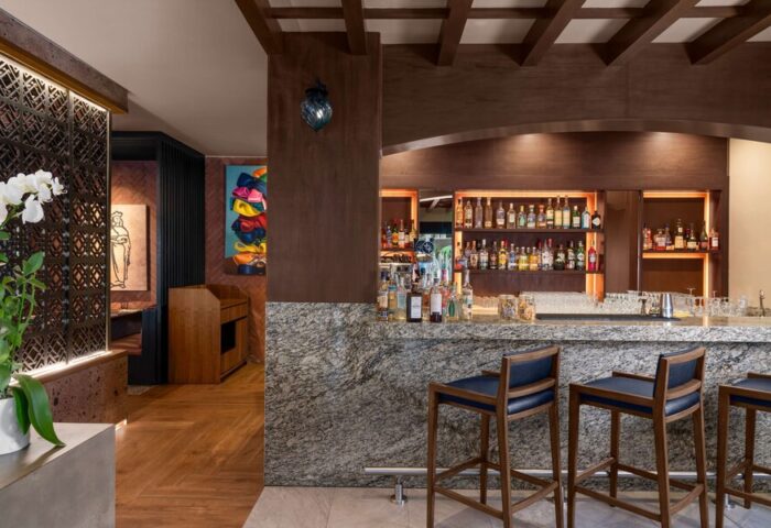 Bar area at Hilton Cancun Mar Caribe All-Inclusive Resort. Bottles on shelves, bar stools. Gay-friendly hotel for LGBT travelers.