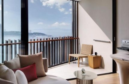 Hilton Pattaya gay-friendly hotel room. Balcony with ocean view, stylish furniture, and modern design. Ideal for gay travelers in Pattaya.