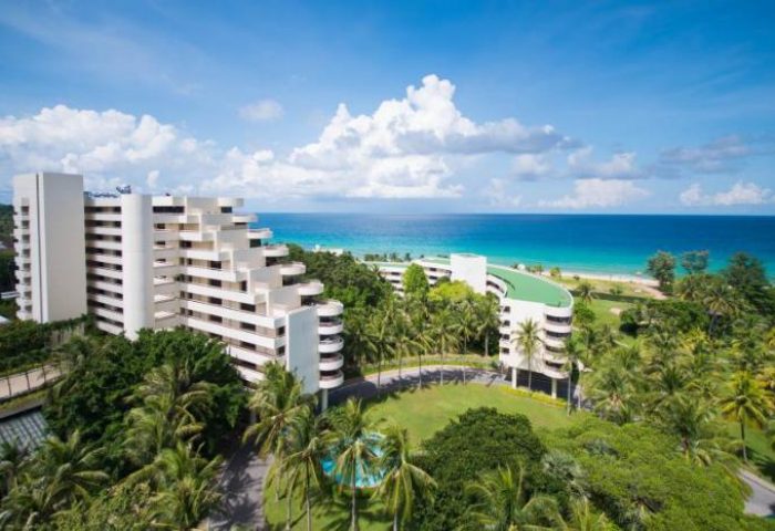 Hilton Phuket Arcadia Resort & Spa, a gay-friendly hotel. Aerial view of the resort, palm trees, beach, and ocean. Perfect for gay travel.