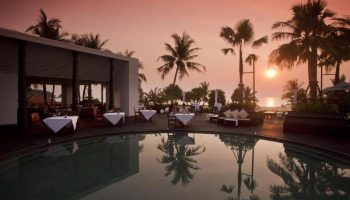 Hilton Phuket Arcadia Resort & Spa pool at sunset. Gay-friendly hotel with dining, palm trees, and ocean views. Perfect for gay travel.