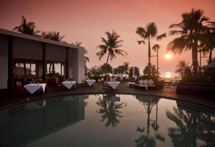 Hilton Phuket Arcadia Resort & Spa pool at sunset. Gay-friendly hotel with dining, palm trees, and ocean views. Perfect for gay travel.