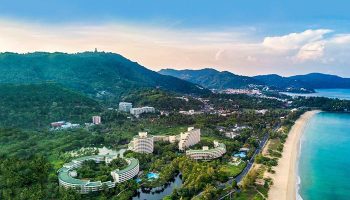 Gay-Friendly Hilton Phuket Arcadia Resort & Spa aerial view. Beachfront hotel with lush greenery, pools, and ocean views. Ideal gay travel spot.