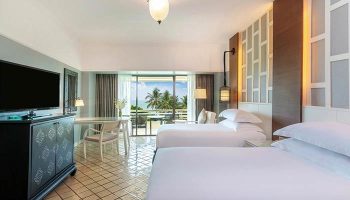 Gay-Friendly Hilton Phuket Arcadia Resort & Spa room. Two beds, desk, TV, balcony with ocean view. Luxury gay travel in Thailand.