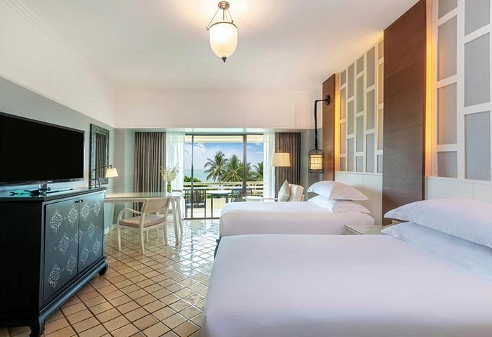 Gay-Friendly Hilton Phuket Arcadia Resort & Spa room. Two beds, desk, TV, balcony with ocean view. Luxury gay travel in Thailand.