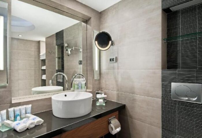 Hilton Tel Aviv gay-friendly hotel bathroom. Modern design with sink, mirror, and toiletries. Ideal for gay men's travel in Tel Aviv.