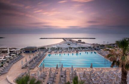 Hilton Tel Aviv gay-friendly hotel pool and beach view at sunset. A luxury travel destination for gay men in Tel Aviv, Israel.