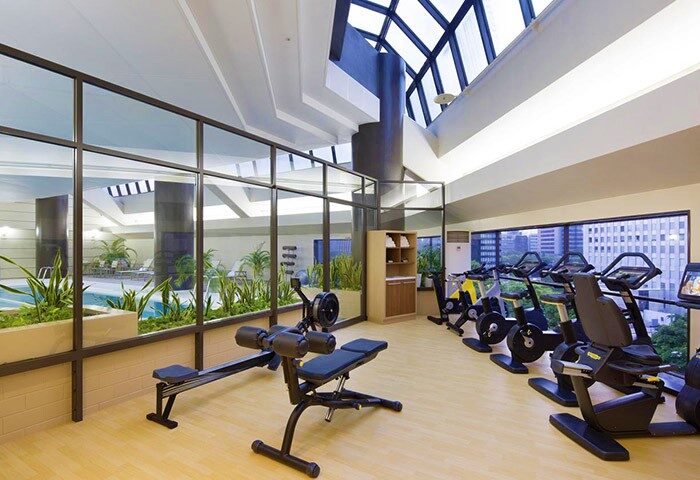 Hilton Tokyo gym. Gay-friendly hotel fitness center with rowing machine, exercise bikes, skylight, and view of the pool. Tokyo travel advice.