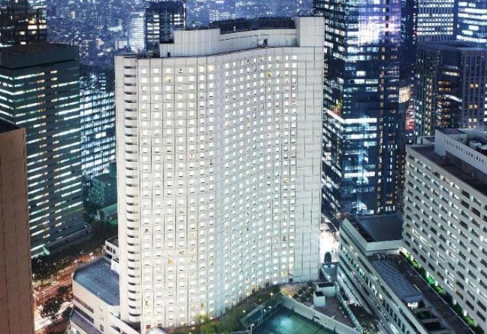 Hilton Tokyo, a gay-friendly hotel, at night. The hotel's lit windows stand out among the city's skyscrapers. A great choice for gay travelers.
