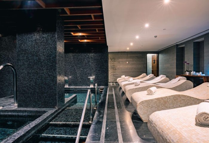 Spa at Hilton Vallarta Riviera All-Inclusive Resort. Lounge chairs line the room, next to a pool. Gay-friendly hotel in Puerto Vallarta.