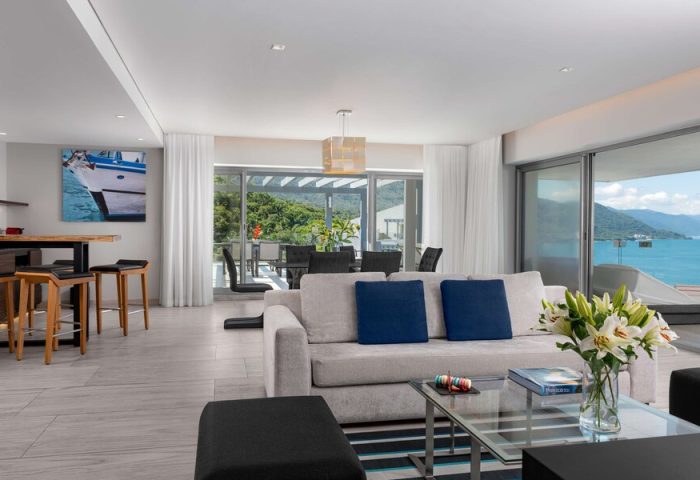 Living area at Hilton Vallarta Riviera All-Inclusive Resort, a gay-friendly hotel. Modern interior with ocean view. Bar stools and sofa.