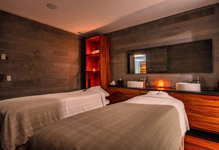 Spa room at Hilton Vallarta Riviera All-Inclusive Resort. Two massage beds, sinks, & ambient lighting. Gay-friendly hotel for men's travel.