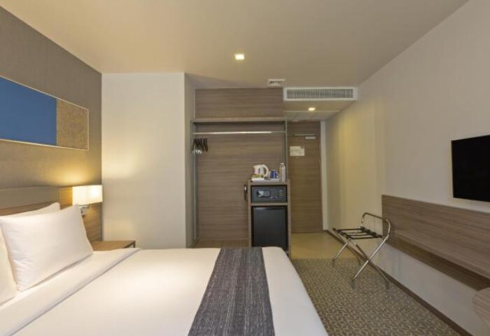 Holiday Inn Express Bangkok Sathorn gay-friendly hotel room. Modern design with bed, closet, safe, and TV. Ideal for gay travelers.