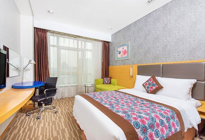 Holiday Inn Express Beijing Dongzhimen room. Gay-friendly hotel with a bed, desk, chair, and window. Comfortable stay in Beijing, China.