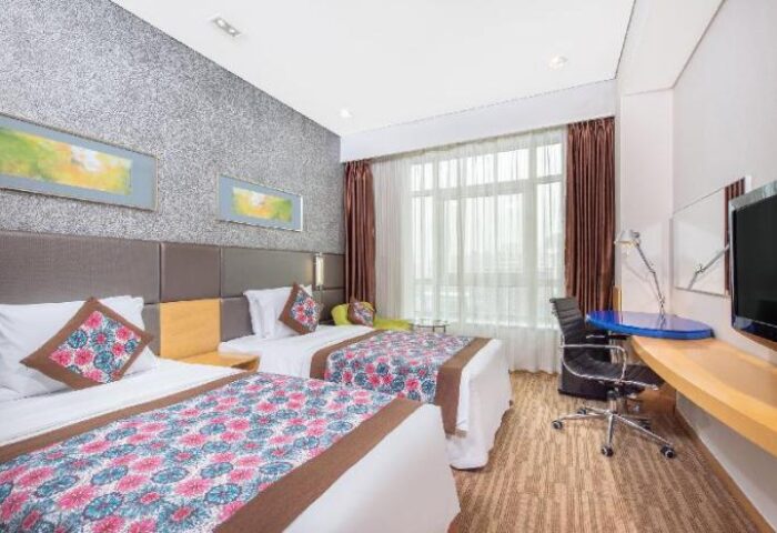 Holiday Inn Express Beijing Dongzhimen gay-friendly hotel room. Two beds, desk, TV, and window with curtains. Comfortable lodging for gay travelers.