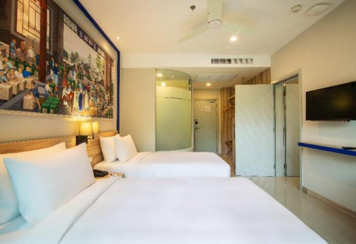 Holiday Inn Express Krabi Ao Nang Beach gay-friendly hotel room. Two beds, TV, bathroom, and mural on the wall. Great for gay travel.