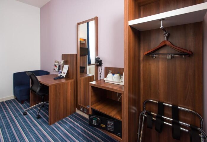 Holiday Inn Express London Vauxhall Nine Elms gay-friendly hotel room. Desk, chair, wardrobe, safe, and luggage rack.