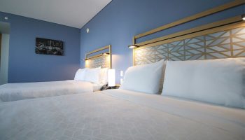 Holiday Inn Express Mexico Reforma gay-friendly hotel room. Two beds with geometric headboards, blue wall, and modern decor.