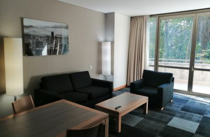 Holiday Inn Express Mexico Reforma suite. Gay-friendly hotel room with sofa, chair, table, and balcony. Modern design.