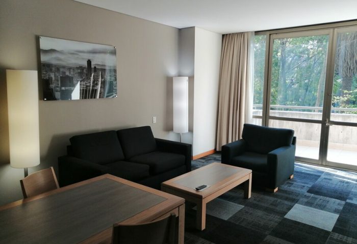 Holiday Inn Express Mexico Reforma suite. Gay-friendly hotel room with sofa, chair, table, and balcony. Modern design.