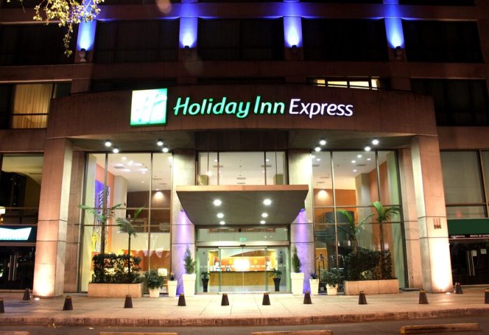 Holiday Inn Express Mexico Reforma, a gay-friendly hotel. Facade view at night with blue lights. Great for gay travel in Mexico City.