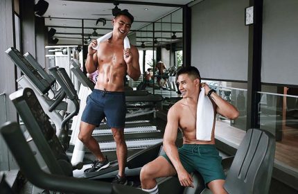 Holiday Inn Express Singapore Clarke Quay gym. Two gay men with towels, shirtless, working out. Gay-friendly hotel in Singapore.