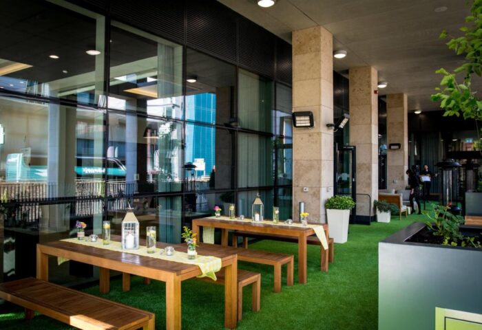 Holiday Inn Manchester City Centre's outdoor patio. Tables with benches on artificial grass. Gay-friendly hotel for gay men travel advice.