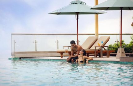Holiday Inn Pattaya gay-friendly hotel pool scene. Couple relaxing by the infinity pool, enjoying the view. Perfect for gay travel in Pattaya.