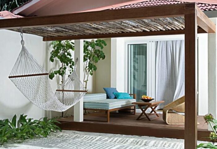 Holiday Inn Resort Kandooma Maldives gay-friendly hotel room. Hammock, daybed, and table on a private deck. Ideal for gay travel.