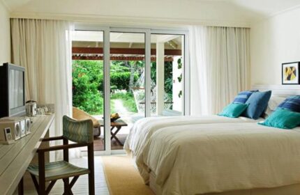 Holiday Inn Resort Kandooma Maldives room. Gay-friendly hotel with twin beds, desk, and patio overlooking lush greenery. Ideal gay travel destination.