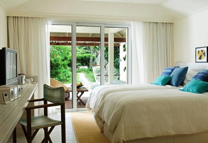 Holiday Inn Resort Kandooma Maldives room. Gay-friendly hotel with twin beds, desk, and patio overlooking lush greenery. Ideal gay travel destination.