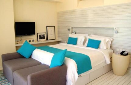 Gay-Friendly Holiday Inn Resort Kandooma Maldives room. Modern design, turquoise accents, comfy bed. Ideal for gay men travel.