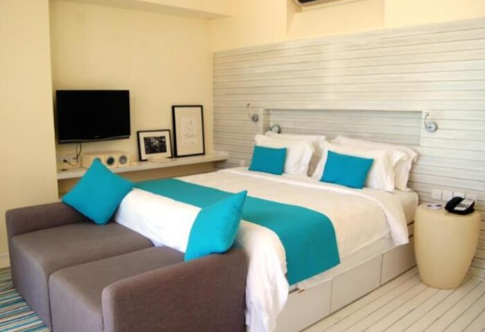 Gay-Friendly Holiday Inn Resort Kandooma Maldives room. Modern design, turquoise accents, comfy bed. Ideal for gay men travel.