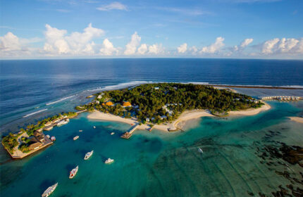 Aerial view of Holiday Inn Resort Kandooma Maldives, a gay-friendly hotel. Boats dot turquoise waters near the island's sandy beaches.