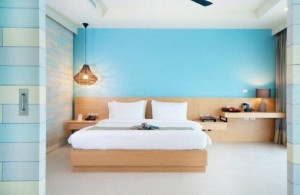 Holiday Inn Resort Krabi Ao Nang Beach gay-friendly hotel room. Modern design with blue wall, wooden bed frame, and ceiling fan.