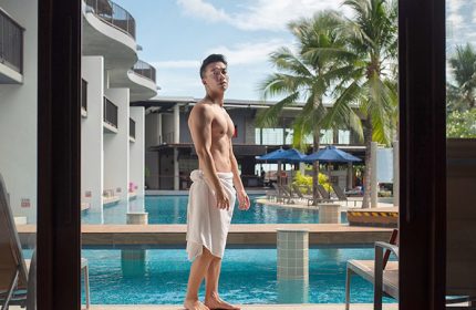 Gay-friendly Holiday Inn Resort Krabi Ao Nang Beach: Man in towel by pool. Tropical gay travel at Ao Nang Beach resort in Krabi, Thailand.