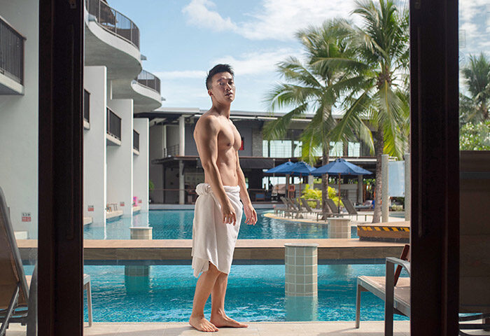 Gay-friendly Holiday Inn Resort Krabi Ao Nang Beach: Man in towel by pool. Tropical gay travel at Ao Nang Beach resort in Krabi, Thailand.